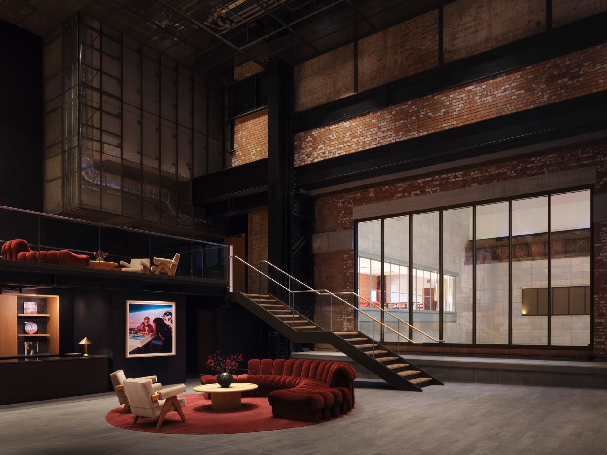 A comfortable foyer with a seating area, a large glass window, and a staircase inside Apple Music Hall.